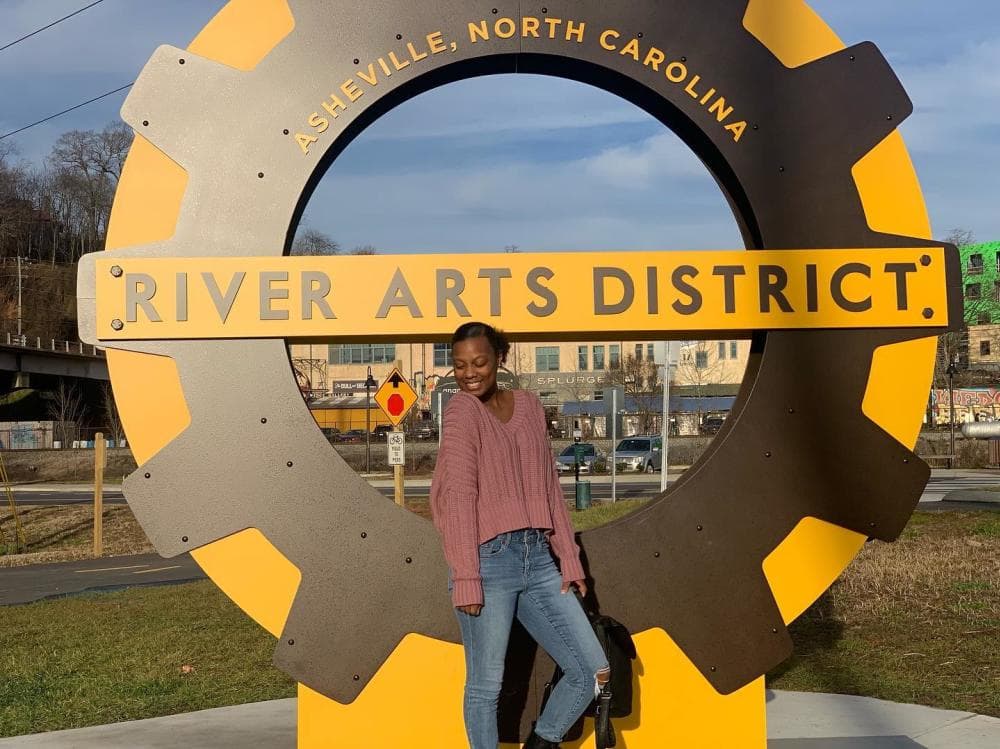 A woman poses with new signage in the River Arts District in Asheville, NC A woman poses with new signage in the River Arts District in Asheville, NC